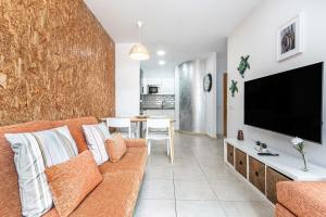 a living room with a couch and a flat screen tv at Casa Almi Las Palmas in Las Palmas de Gran Canaria