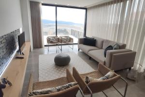 a living room with a couch and chairs and a large window at Douro Barcos House Local in Barcos