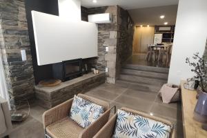a living room with two chairs and a fireplace at Douro Barcos House Local in Barcos