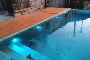 a pool with a wooden deck and lights in it at Douro Barcos House Local in Barcos
