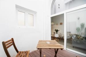 a room with a wooden table and a chair at Piso con Encanto 2 in Cádiz +13 photos