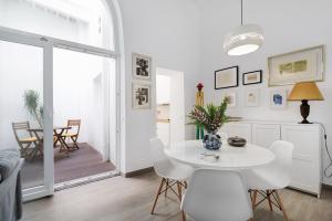 a white dining room with a white table and chairs at Piso con Encanto 2 in Cádiz