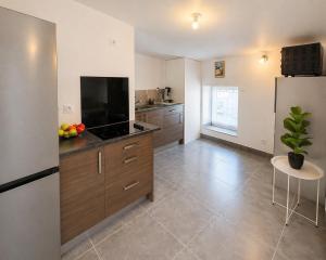 a large kitchen with a refrigerator and a table at Appartement Andance in Andance