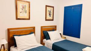 two beds in a room with blue doors at Casa da Dóta no paraíso de Furnas e Capitólio in São José da Barra +25 photos