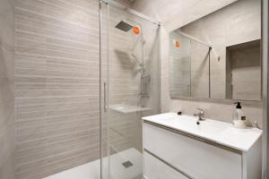a white bathroom with a shower and a sink at Piso con Encanto 2 in Cádiz