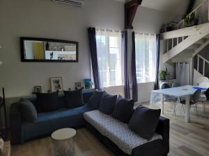 a living room with a blue couch and a table at Gite des Coteaux Pmr in Sainte-Maure-de-Touraine
