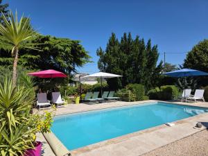 a swimming pool with chairs and umbrellas at Gite des Coteaux Pmr in Sainte-Maure-de-Touraine