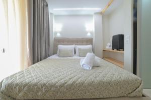 a bedroom with a bed with pillows and a television at Sunset View House In Chalkidiki in Nea Potidaea