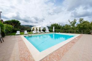 a swimming pool with chairs and a gazebo at Antico Casale Gioiosa Marea in Gioiosa Marea