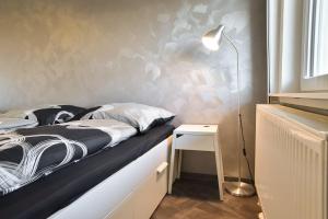 ein Schlafzimmer mit einem Bett, einer Lampe und einem Tisch in der Unterkunft Apartment Grey Stuttgart in Stuttgart