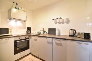 eine Küche mit weißen Schränken und einer Arbeitsplatte in der Unterkunft Apartment Grey Stuttgart in Stuttgart