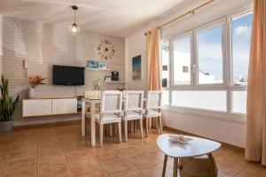 a living room with a table and chairs and a tv at Casa Yerida in El Cotillo