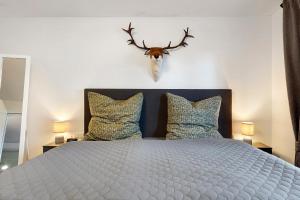 a bedroom with a bed with a headboard and two pillows at Panoramablick und Ruhe in Titisee-Neustadt