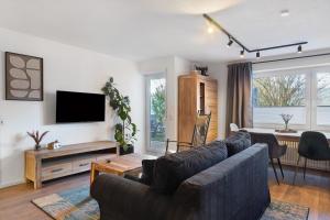 a living room with a couch and a tv at Panoramablick und Ruhe in Titisee-Neustadt