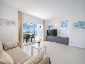 a living room with a couch and a television and a table at Apartment Xisca by Interhome in Port d'Alcudia