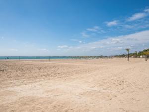 a sandy beach with palm trees and the ocean at Apartment Xisca by Interhome in Port d'Alcudia