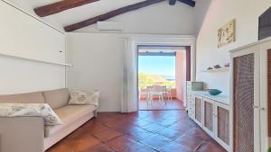 a living room with a couch and a table at Monolocale Porto Sole N 4 in Baja Sardinia