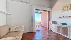 a living room with a couch and a table at Monolocale Porto Sole N 4 in Baja Sardinia