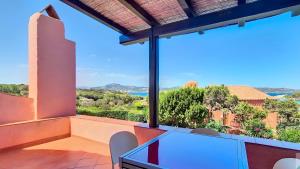 a view from the balcony of a house with a table and chairs at Monolocale Porto Sole N 4 in Baja Sardinia +11 photos
