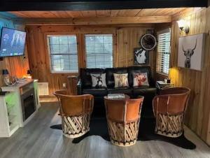 a living room with a black couch and chairs at Prickly Pear - Rustic Cabin in New Braunfels