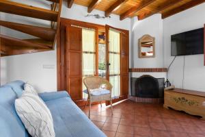a living room with a blue couch and a fireplace at La Llosona in Caño