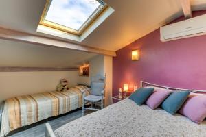 a attic bedroom with a bed and a skylight at Villa Angelo - Lavande in Saint-Thibéry +21 photos