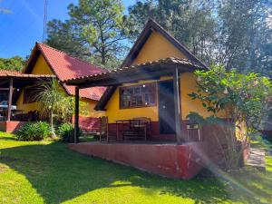 ein kleines gelbes Haus mit rotem Dach in der Unterkunft Cabañas Lupita 22 in Mazamitla