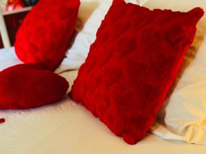 two red pillows sitting on top of a bed at "glamappartspa" design experience & Parking in Dijon