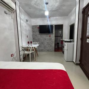 a bedroom with a bed and a table and a kitchen at Hotel Beraka in Fortul