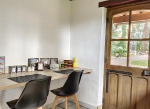 a room with a desk with two chairs and a window at Le Chalêt La Neverdiere in Ygrande