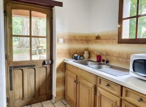 a kitchen with a sink and a microwave at Le Chalêt La Neverdiere in Ygrande