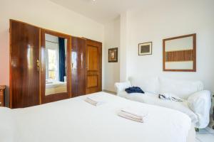 a bedroom with a large white bed and a mirror at Domus Luna in Giba