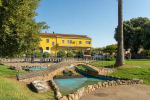 a bridge over a river in front of a yellow building at Domus Luna in Giba