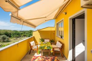 a balcony with a table and chairs and an umbrella at Domus Luna in Giba