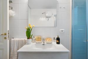 a white bathroom with a sink and a mirror at La Perla House in Anacapri +21 photos