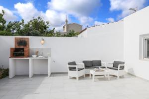 a white patio with chairs and a table at Villa Aday and Ixeia in Cala Blanca