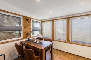 a dining room with windows and a table and chairs at Ferienhaus Stauseeblick in Kelbra