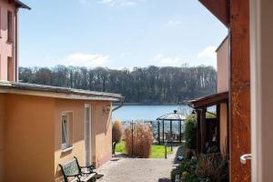 a view of a lake from between two buildings at Moewentraum in Malchow