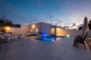 a villa with a swimming pool at night at Villa Aday and Ixeia in Cala Blanca