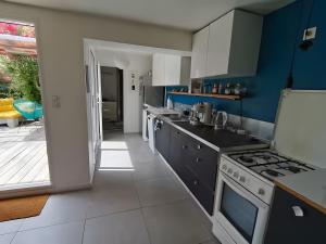 a kitchen with blue and white cabinets and a stove at Maison Entre Les Ports in Les Sables-d'Olonne +2 photos