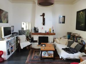 a living room with a couch and a fireplace at Maison Entre Les Ports in Les Sables-d'Olonne