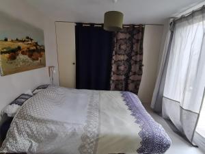 a bedroom with a bed and a blue curtain at Maison Entre Les Ports in Les Sables-d'Olonne