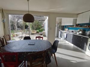 a kitchen with a table with chairs and a dining room at Maison Entre Les Ports in Les Sables-d'Olonne