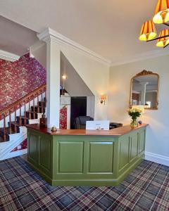 a room with a green counter with a staircase at Corse Lawn House Hotel in Corse