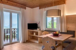 a living room with a dining room table and a television at Haus Lohengrin Ferienwohnung 2 in Siusi