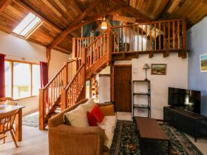 a living room with a staircase and a couch at Swallows Nest in Newton Abbot