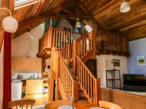 a wooden spiral staircase in a kitchen with a table at Swallows Nest in Newton Abbot