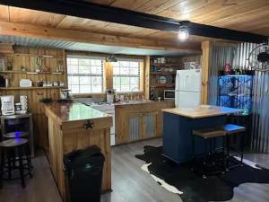 a kitchen with wooden cabinets and a white refrigerator at Prickly Pear - Rustic Cabin in New Braunfels