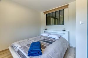 ein Schlafzimmer mit einem Bett, auf dem ein blaues Handtuch liegt in der Unterkunft La source Amélie in Saint-Pancrasse + 22 Fotos