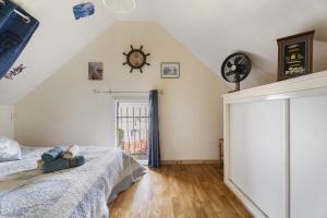 a bedroom with a bed and a clock on the wall at Maison Kaoz Korriganez in La Boussac